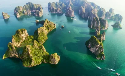 Vue panoramique aérienne des îlots karstiques verdoyants dispersés sur les eaux émeraude de la baie d'Ha Long.