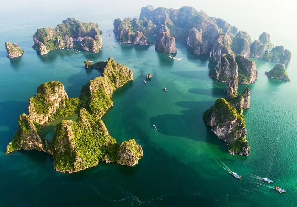 Vue panoramique aérienne des îlots karstiques verdoyants dispersés sur les eaux émeraude de la baie d'Ha Long.
