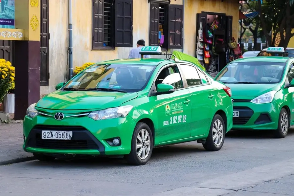 Taxis verts de la compagnie Mai Linh stationnés au bord de la route pour le transport des voyageurs.