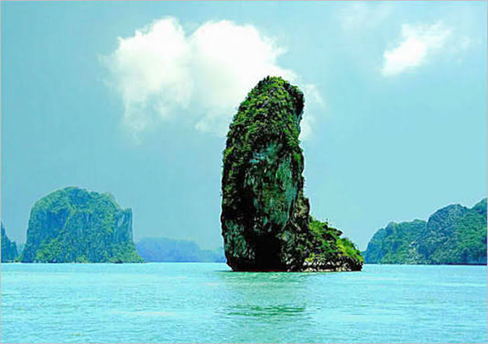 La silhouette singulière de Hòn Ngón Tay émergent des eaux calmes sous un ciel dégagé.